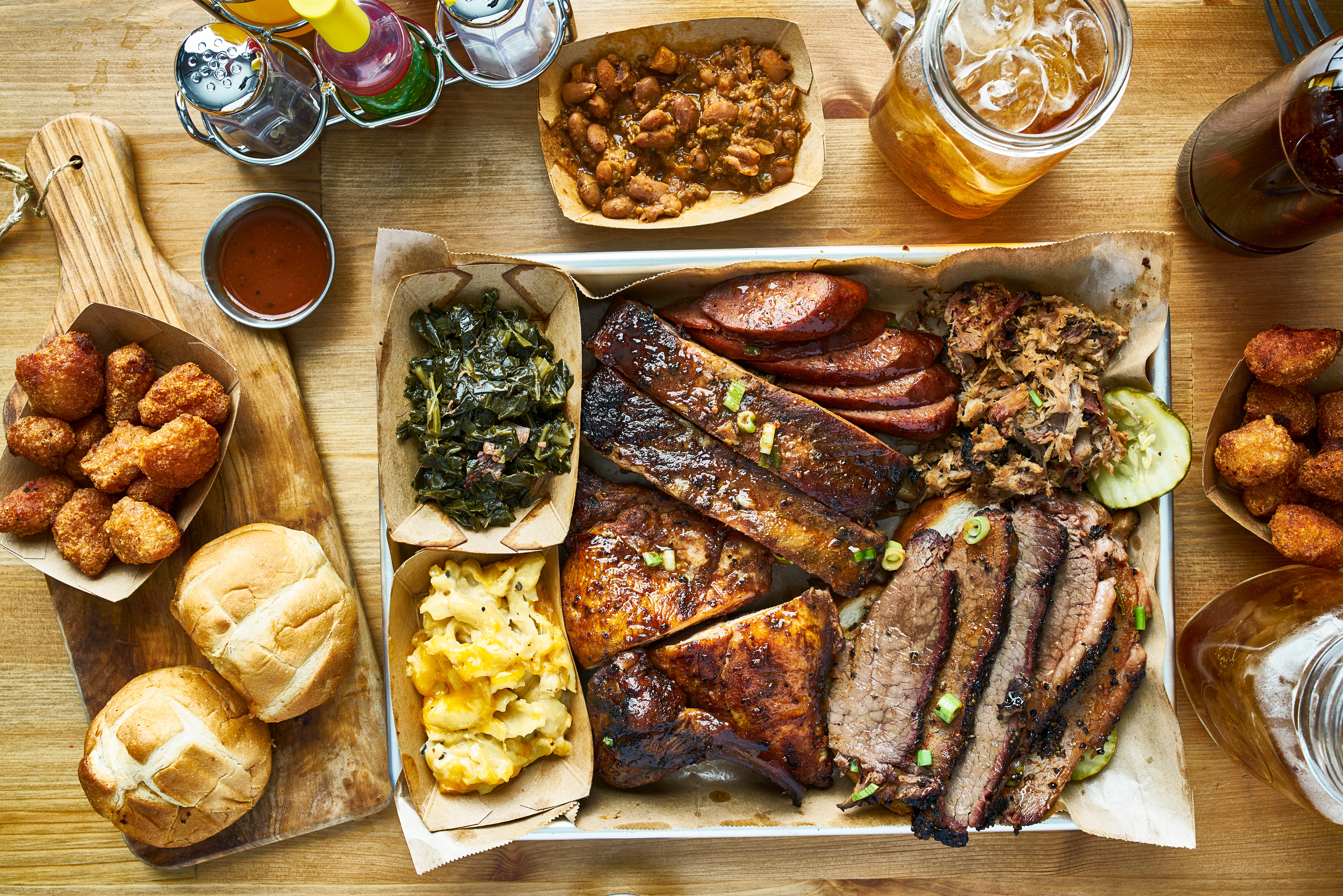 Overhead barbecue feast with brisket, ribs, sausage, chicken, and sides