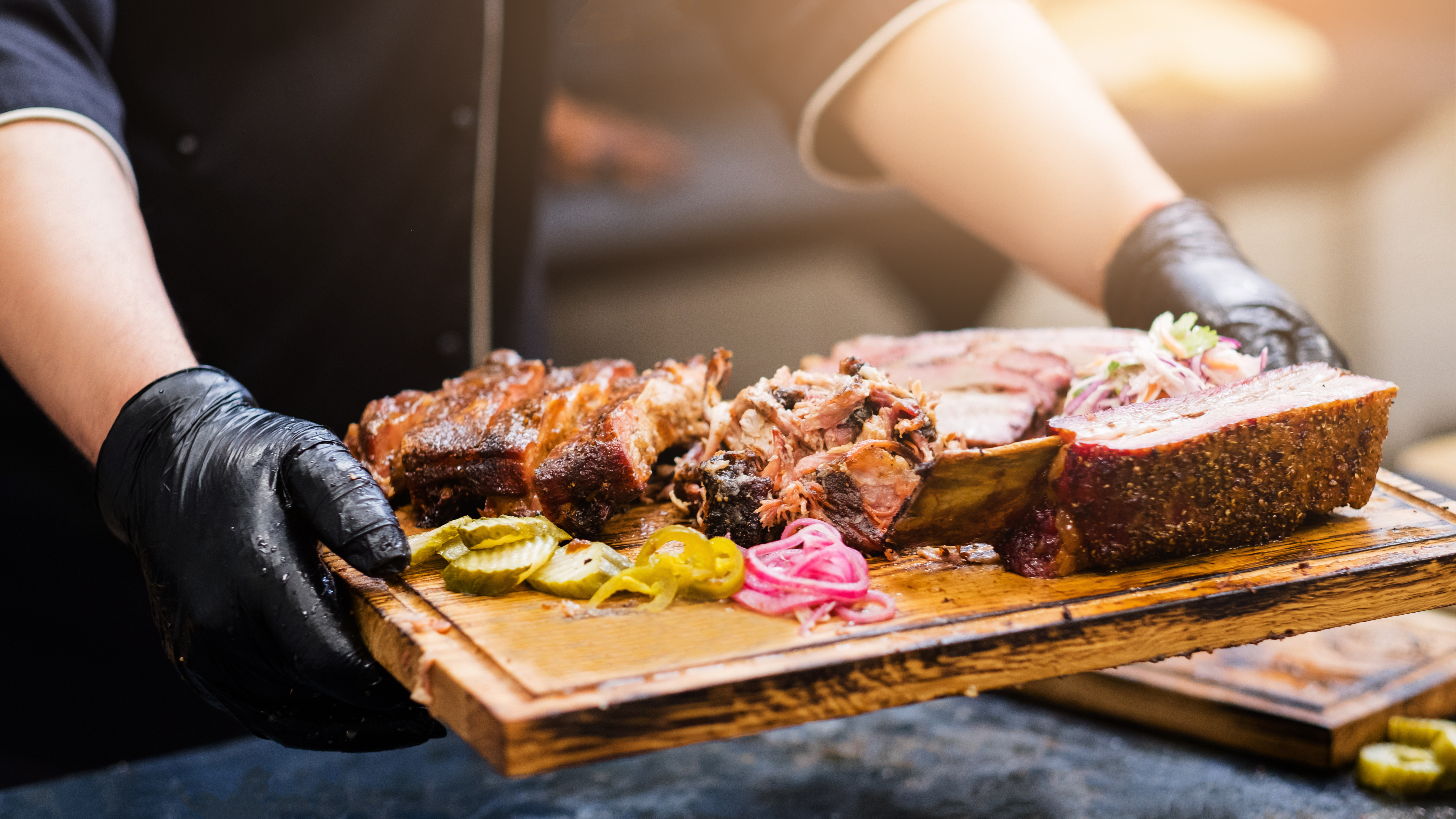 Barbecue platter served with brisket, ribs, pulled pork, and pickles